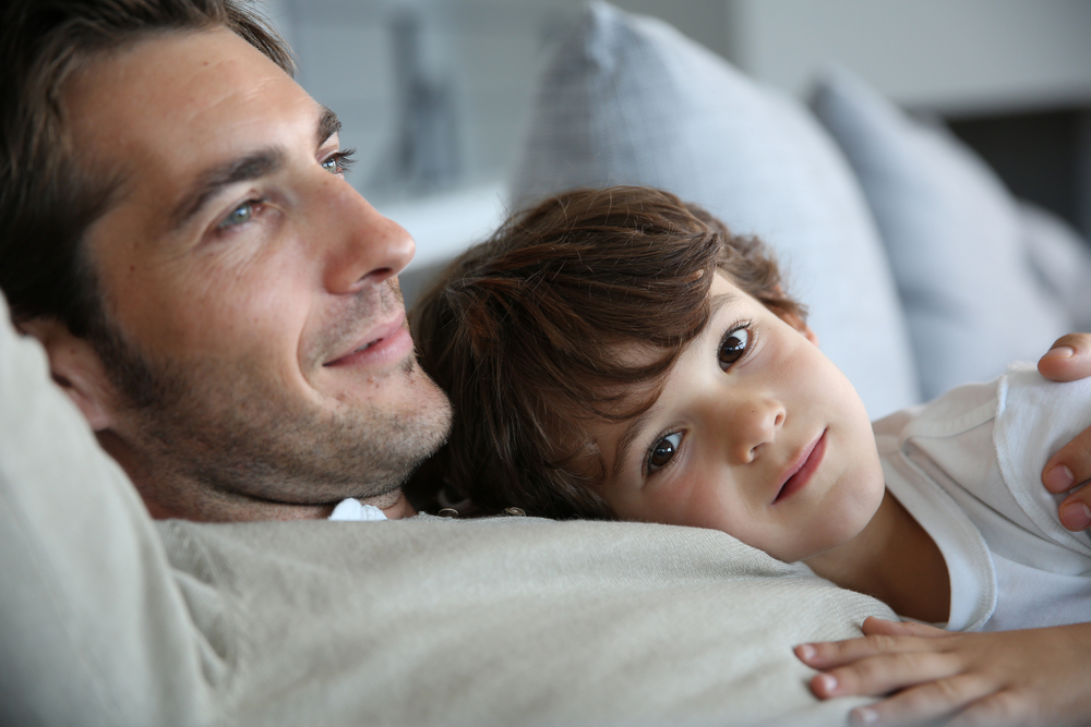 Boy with daddy relaxing on his chest